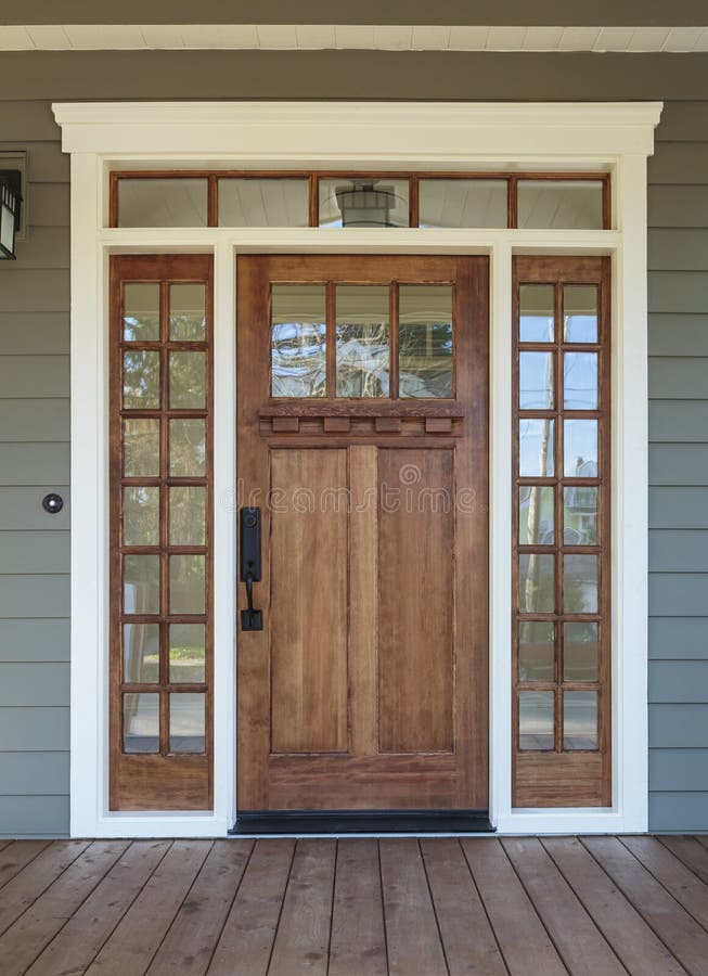 Exterior shot of a Wooden Front Door. Vertical shot of wooden front door of an upscale home with windows royalty free stock photography
